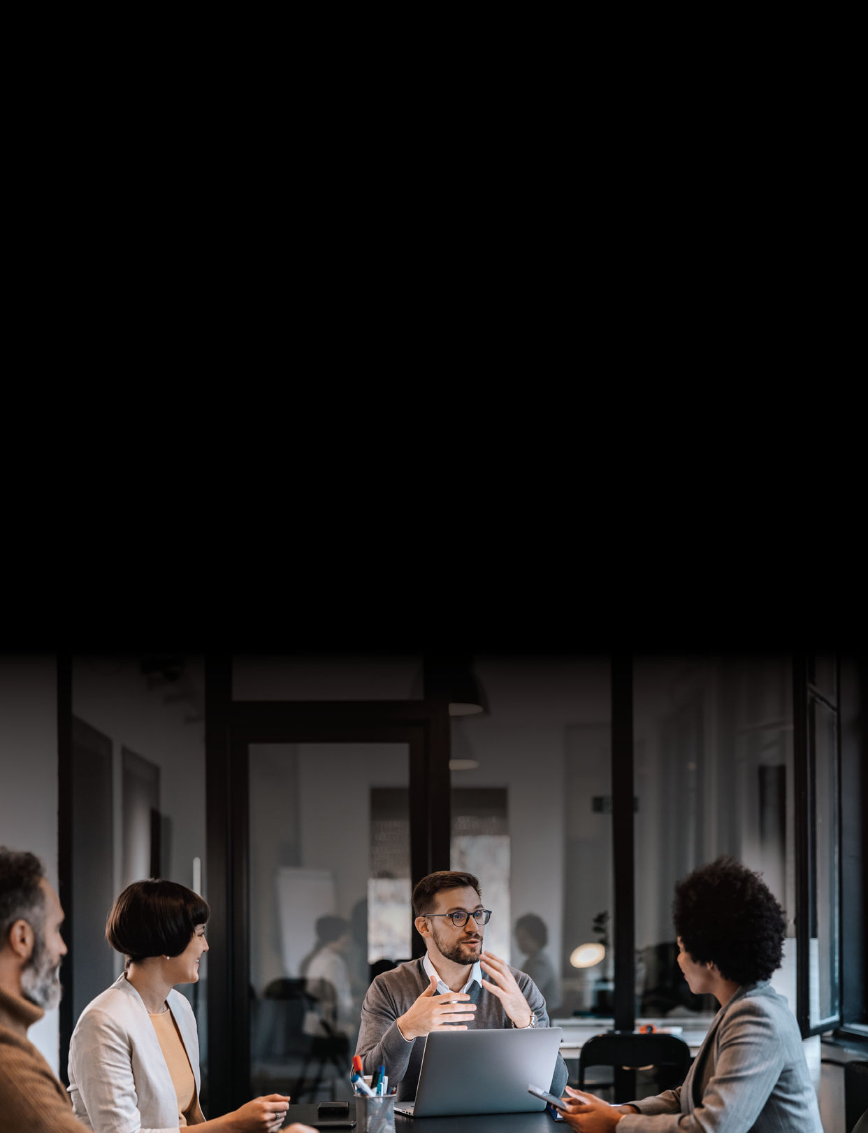 A focused mentor is explaining project to mentees at the boardroom at enterprise.